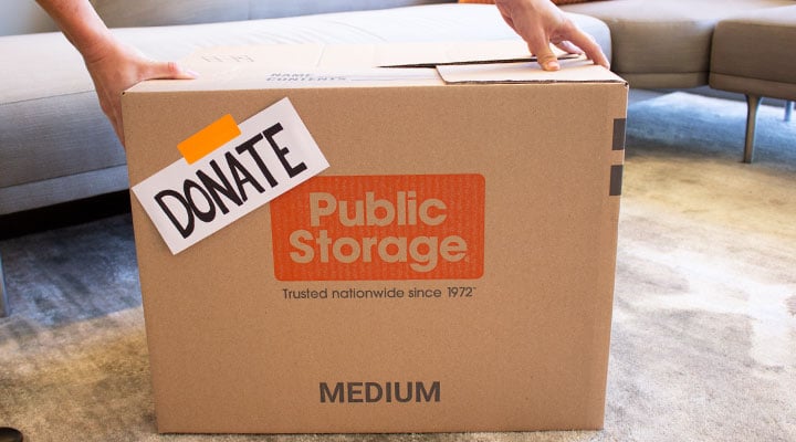 a donate box while packing for moving is placed on the floor by a person